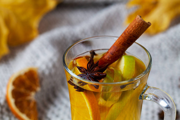close-up mulled wine and spices.Mulled drink on knitting plaid with copy space. Christmas hot white mulled wine in glass with honey, cinnamon sticks and star anise on light background. - Foto, Imagem