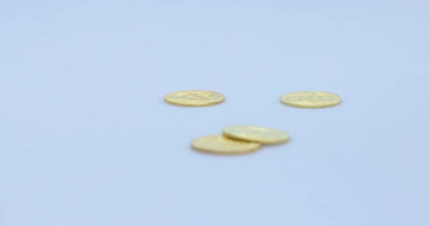 Criptomonete d'oro, bitcoin e litecoin che cadono su una pila e rotolano su uno sfondo grigio morbido - Filmati, video