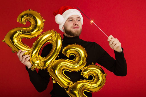 Een man in een kerstman hoed heeft de nummers 2022 en een sterretje - Foto, afbeelding