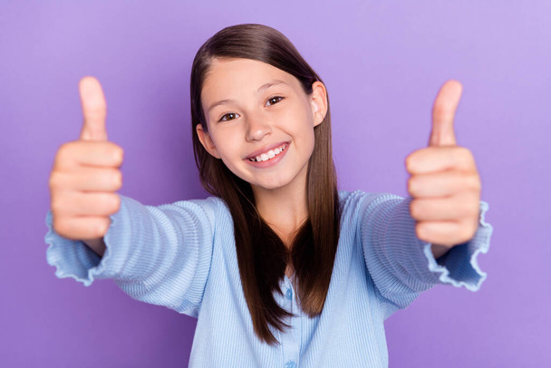 Photo of lovely brunette small girl show thumb up wear blue shirt isolated on violet color background - Foto, Imagen