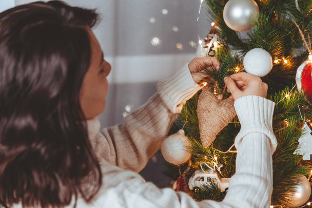 женщина позирует и украшает рождественскую елку - Фото, изображение