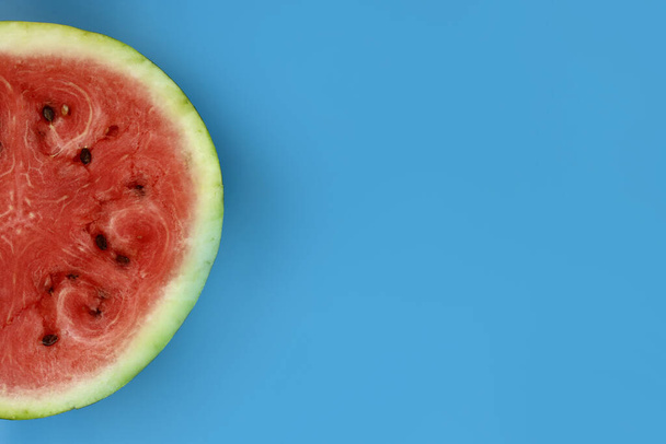 half of fresh watermelon on a blue background. Copy space for text - Zdjęcie, obraz