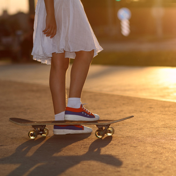 Les jambes adolescentes en baskets sur skateboard
 - Photo, image