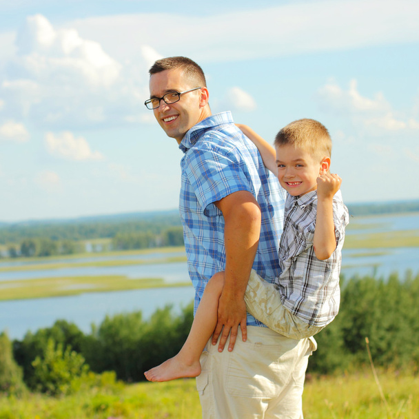 Отец катает своего сына на спине
 - Фото, изображение