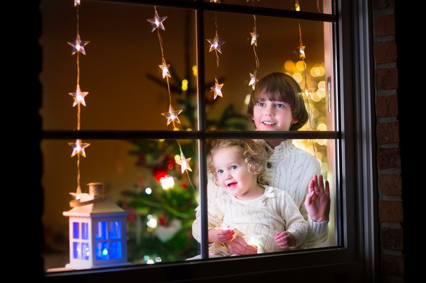 gyerekek a ablak-karácsony estéjén - Fotó, kép