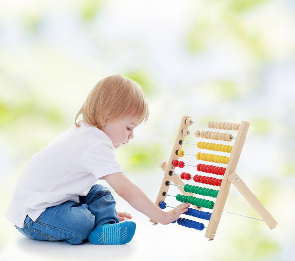 Little boy is counting on the abacus. - Photo, image