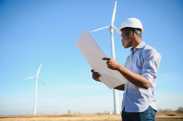 Engineer African man standing with wind turbine - Photo, image