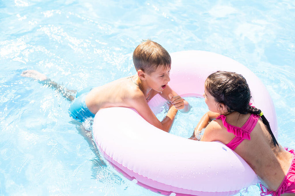 Дети веселятся, играя в бассейне на летних каникулах - Фото, изображение