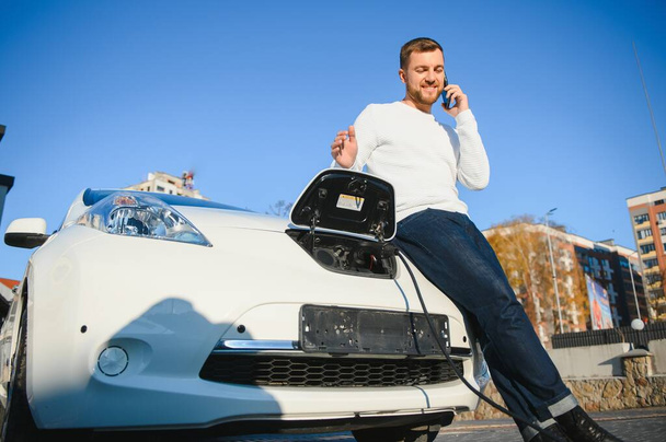 Young man charging his car - Foto, imagen
