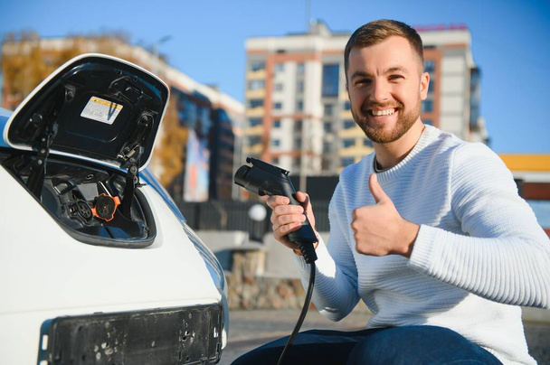 Man turning on charging of car - Valokuva, kuva