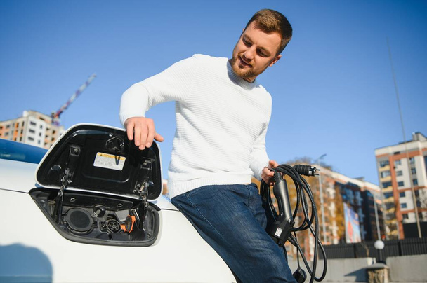 Man turning on charging of car - Photo, image