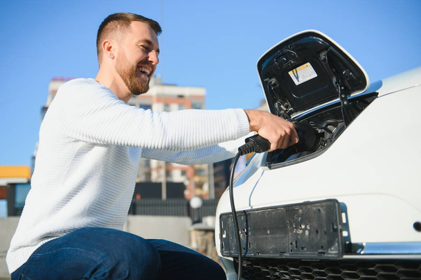 Man turning on charging of car - Photo, Image
