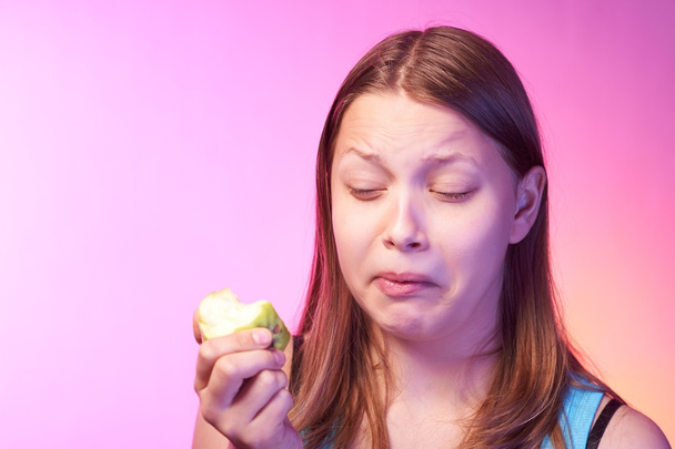 Teen girl eating disgusting apple - Fotografie, Obrázek