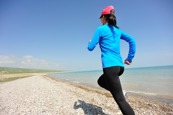 Runner athlete running on stone beach of qinghai lake - Foto, afbeelding