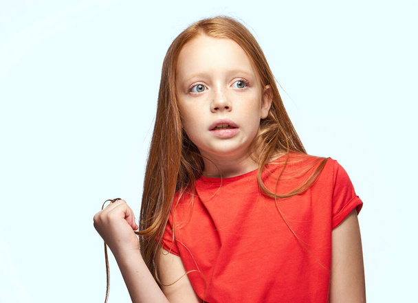 girl with red hair posing red t-shirt childhood - Foto, immagini