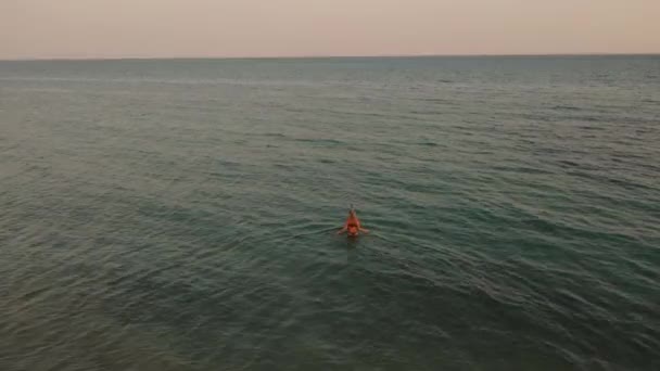 4k кадри над чистим заходом сонця. Молода жінка приходить у воду океанський купальник бікіні снорклінг дайвінг маска
.  - Кадри, відео