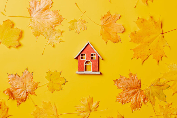Malý domeček na hraní a javorový listí na žlutém pozadí. Horní pohled - Fotografie, Obrázek