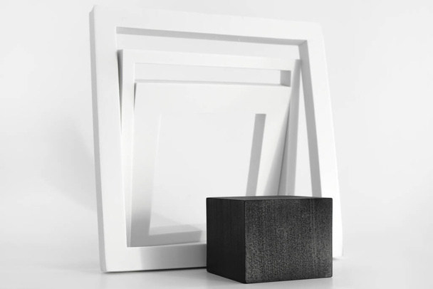 白い背景に白いシンプルな幾何学的な形の黒の表彰台。製品のための表彰台、化粧品プレゼンテーション。創造的なモックアップ。美容製品のための台座またはプラットフォーム. - 写真・画像