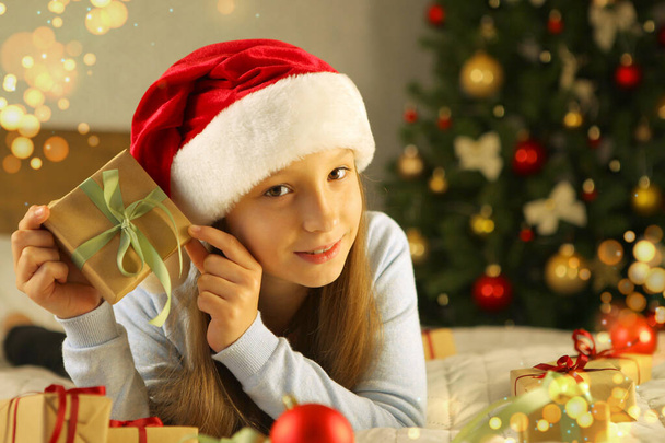 schönes kleines Mädchen in guter Laune mit Geschenken im Weihnachtsinterieur. - Foto, Bild