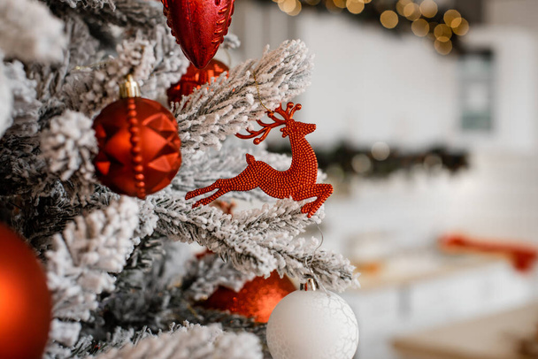 Λευκή χριστουγεννιάτικη διακόσμηση με μπάλες σε κλαδιά ελάτης με θολή φόντο - Φωτογραφία, εικόνα