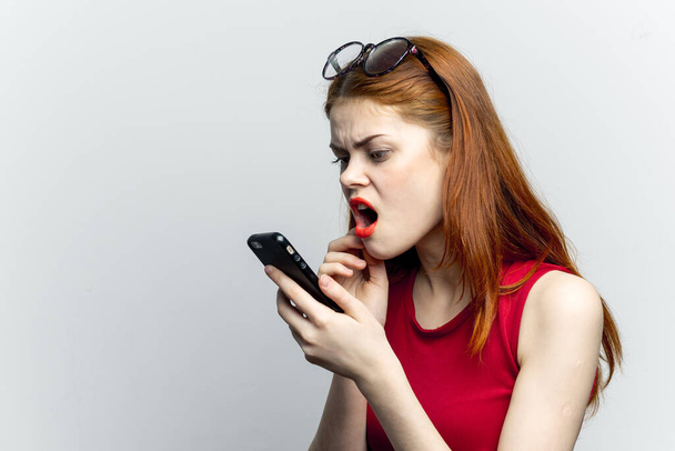 emotional red-haired woman with a phone in her hands communicating gadget - Foto, Imagem