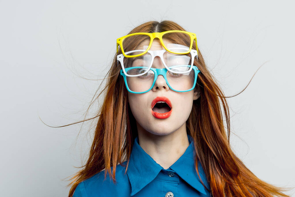 woman with multicolored glasses on her face in blue shirt posing glamor - Foto, imagen