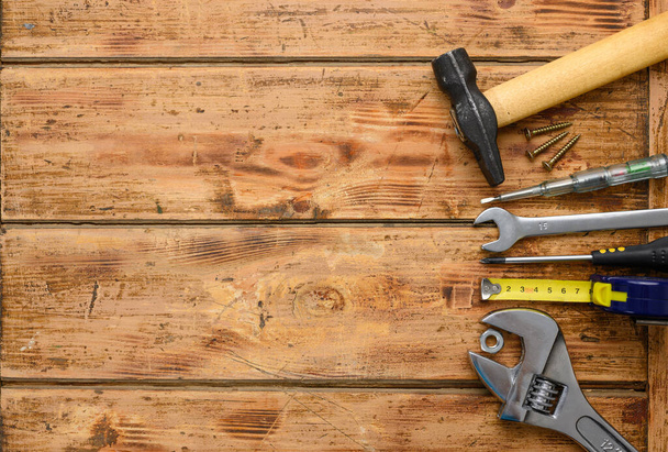Construction tools on a wooden background. Top view, free white space on the left. - Φωτογραφία, εικόνα
