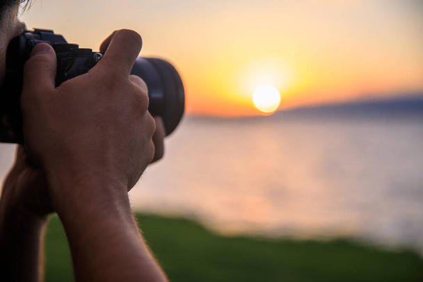 photographer takes photo on the sea backgroun - Fotografie, Obrázek