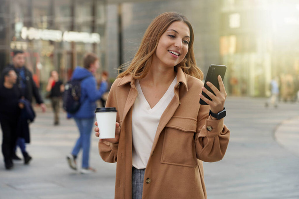 Young business people. Smartphone using. Take away coffee. Smart watch. Black friday shopping. Christmas. Blurred people background. - Foto, immagini