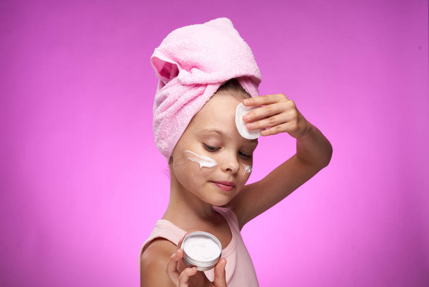 girl with a towel on her head cosmetics decoration close-up purple background - Photo, image