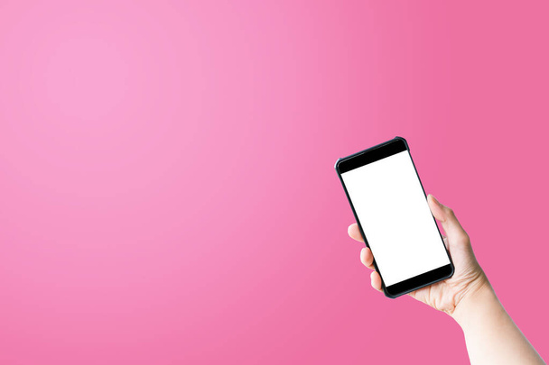 Hand holding smartphone and white screen on pink background. - Foto, immagini