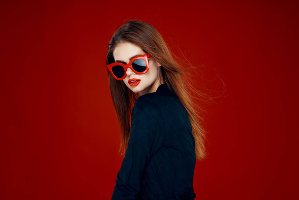 pretty woman wearing sunglasses fashion posing hairstyle red background - Foto, imagen