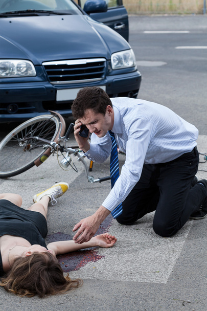 Man calling an ambulance for injured woman - Foto, afbeelding