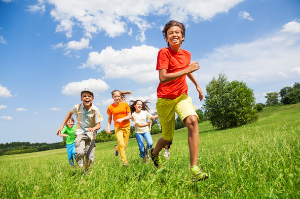 Happy children running together in field - 写真・画像