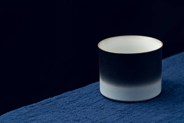 A delicate teacup was placed on the dark blue tablecloth - Fotoğraf, Görsel