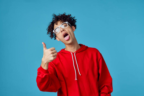 curly guy in a red sweater posing fashion modern hipster style - Zdjęcie, obraz