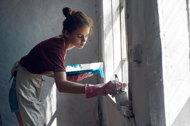 woman painter paints window with brush renovation interior decoration - Zdjęcie, obraz