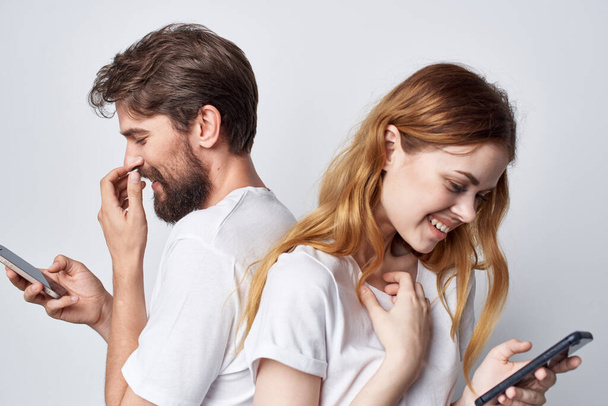 man en vrouw familie met telefoons in de hand communicatie geïsoleerde achtergrond - Foto, afbeelding