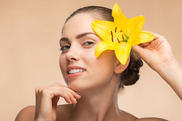 Beautiful girl in spa with flower near her face - Foto, Imagen