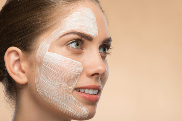 Beautiful girl in spa with cosmetic cream on her face - Фото, зображення