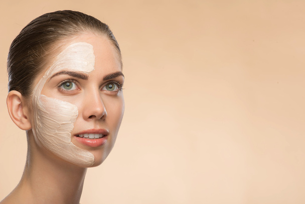 Beautiful girl in spa with cosmetic cream on her face - Foto, Imagem