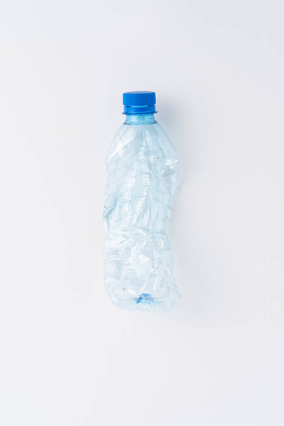 Empty and crushed bottle of water isolated on white background. Plastic recycling concept - Fotó, kép