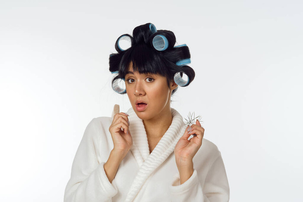 Woman in white coat curlers on her head homework - Фото, изображение