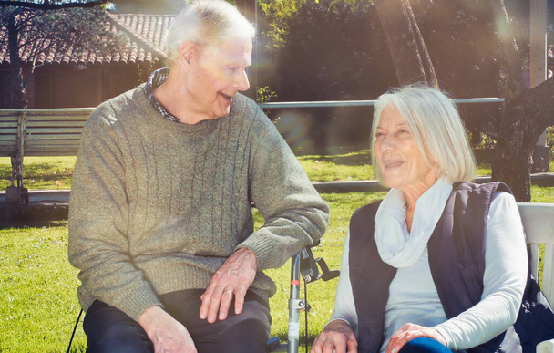 Glückliches Rentnerpaar unterhält sich an einem sonnigen Tag im Freien. - Foto, Bild