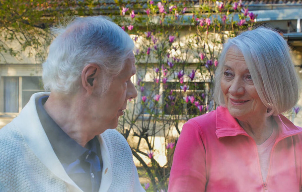 Bělošský pár v důchodu si povídá na zahradě. Koncept odchodu do důchodu a relaxace. - Fotografie, Obrázek