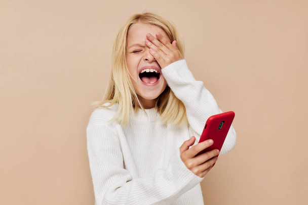 šťastný roztomilý dívka komunikace smartphone zábava na béžové pozadí - Fotografie, Obrázek
