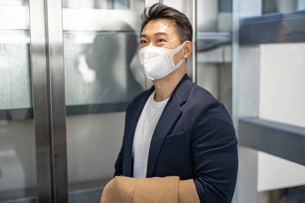 Man and woman in medical masks in elevator - Photo, image
