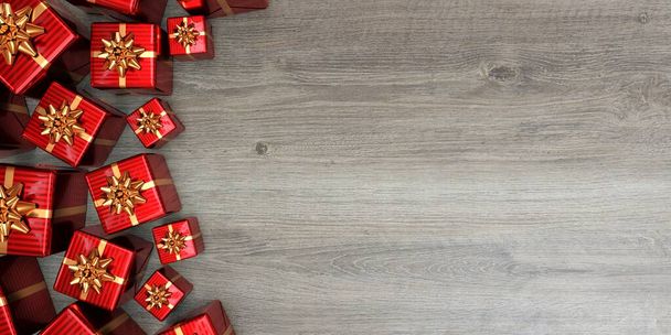 Cadeaux de Noël rouges avec des arcs dorés vus d'en haut. fond bois - rendu 3D - Photo, image