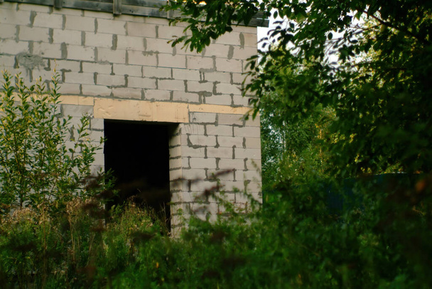 casa de tijolo inacabado na borda da floresta, no verão - Foto, Imagem