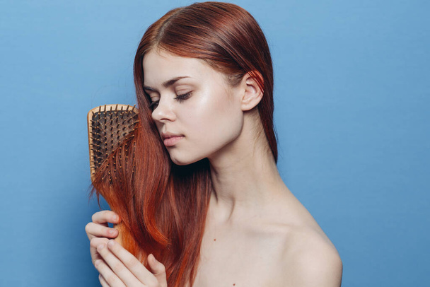 pretty woman combing hair bare shoulders hair care - Foto, immagini